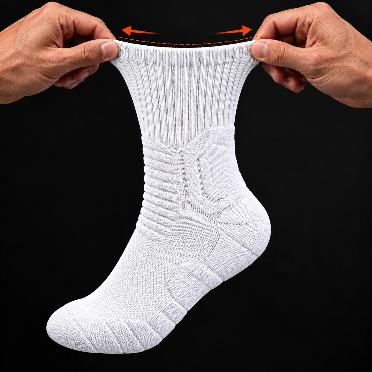 Hands gently widening a white sock cuff, showing the outlined ankle panel, horizontal ankle ribs and bands across the foot; orange arrows indicate cuff stretch